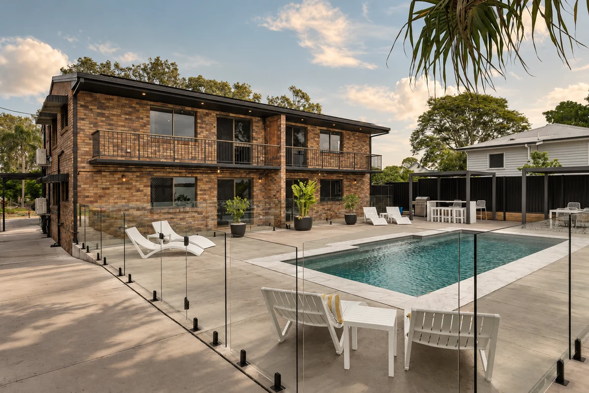 The brick oceanfront units, exposed concrete terrace and glass-fenced pool