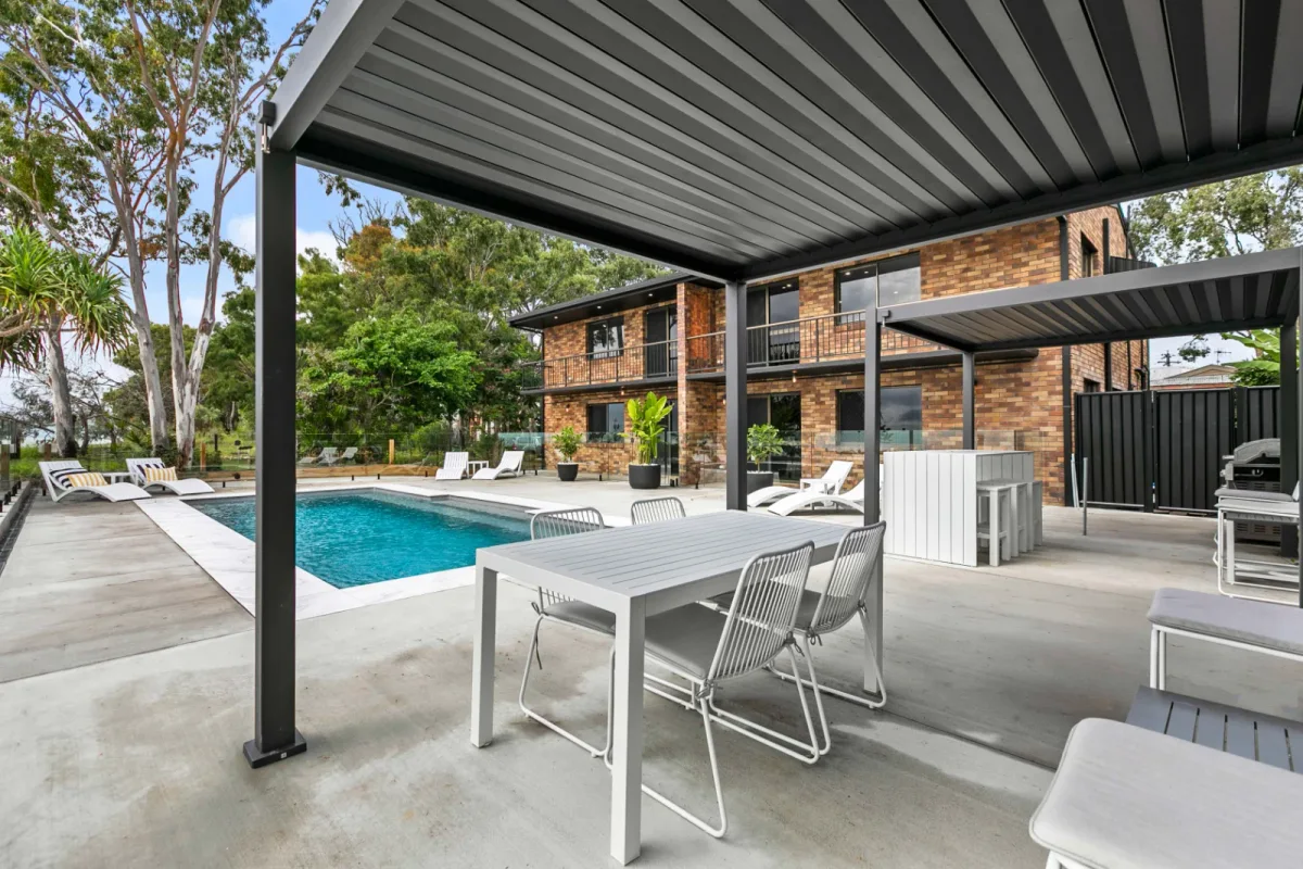 Outdoor dining under the black gazebo beside the oceanfront pool