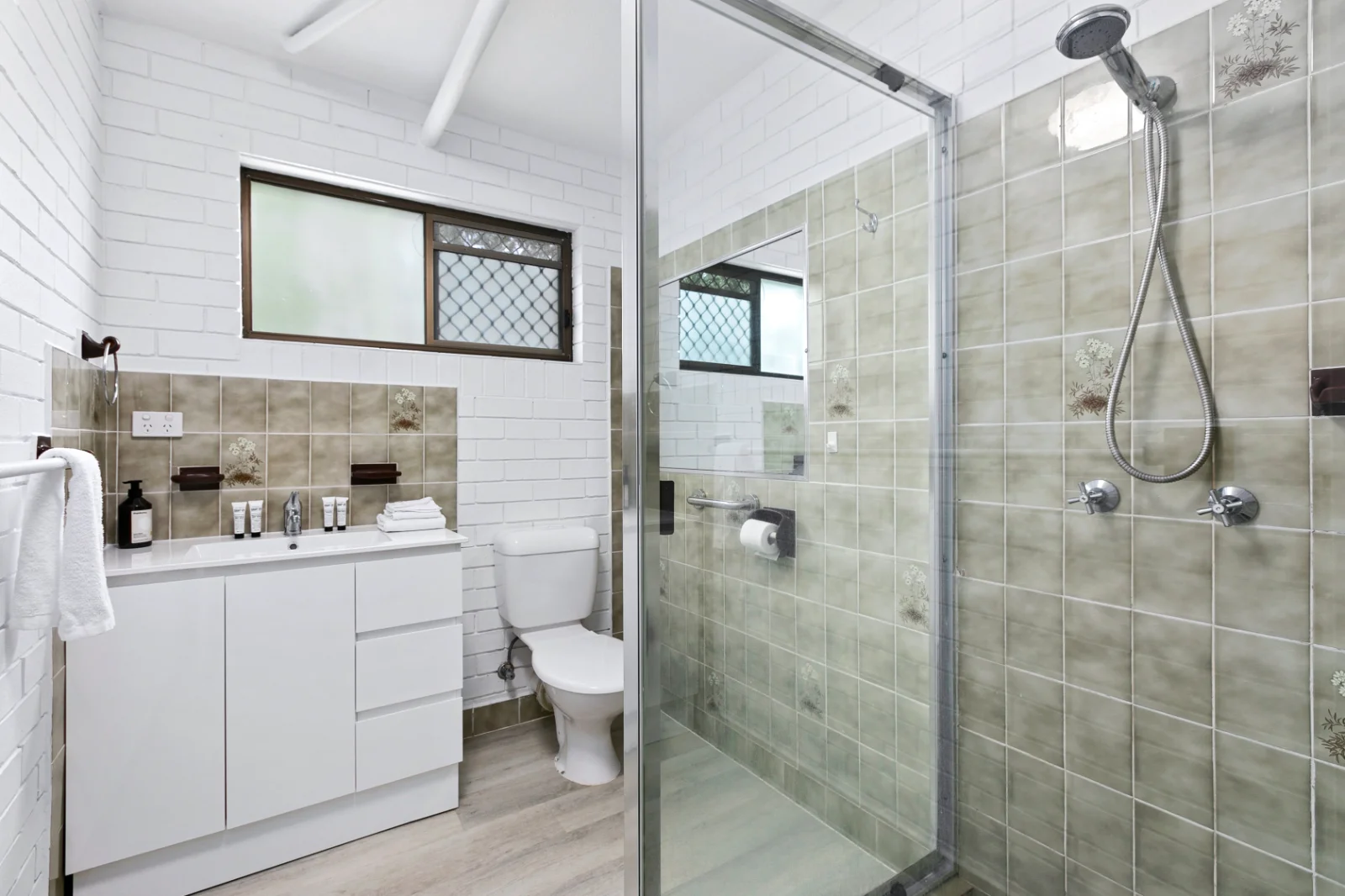 Oceanfront unit bathroom with a glass shower and white vanity